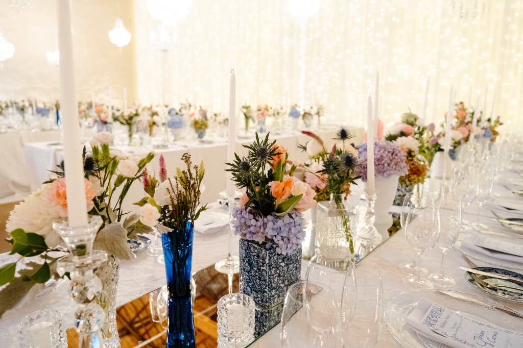 My Pretty Vintage Wedding Décor & Floral Stylist & Wedding Hire. Paarl Guest Table with Chrystal Chandeliers, Mirror Centre, White Blue Delft Dinnerware with Colourful Flower