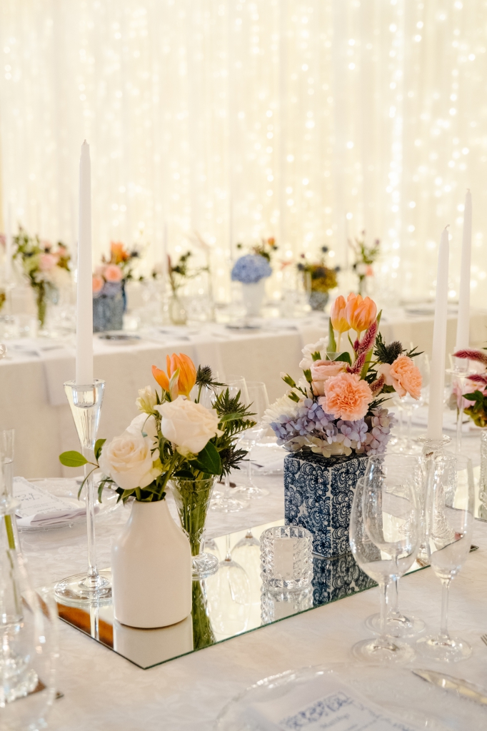 My Pretty Vintage Wedding Décor and Floral Stylist & Wedding Hire. Guest Table with Chrystal Chandeliers, Mirror Centre, White Blue Delft Dinnerware with Colourful Flowers