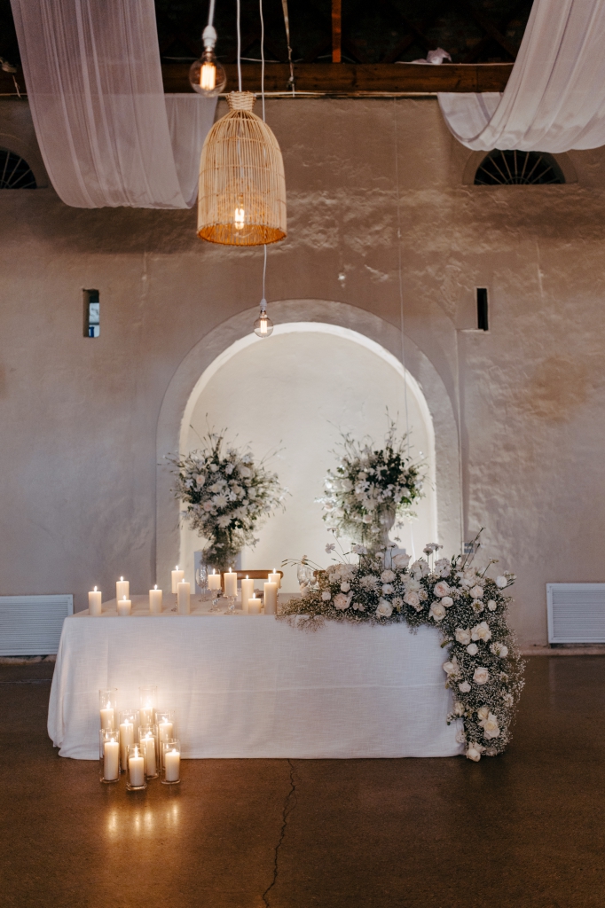 My Pretty Vintage Paarl Wedding Event Décor Hire: Ceiling Draping, Bridal Tablescape with White Flower Filled Urns and Arch Backdrop, Table Décor, Candle Decoration, Green White Roses, White Irisis, White Chrysanthanums, White Chinks, and Gypsophila